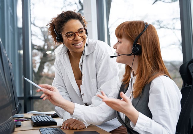 Two contact centre agents discussing a call