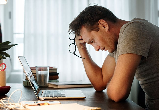 Man at his desk looking burnt out