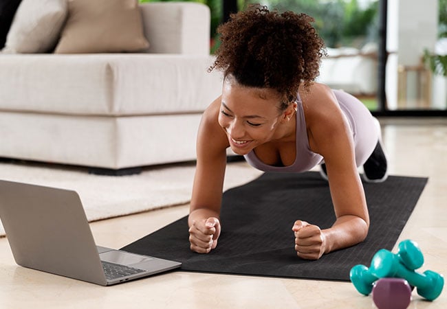 Woman working on her laptop while exercising 