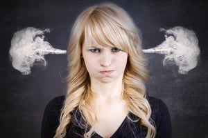 Closeup portrait of angry young woman, blowing steam coming out of ears, about to have nervous atomic breakdown, isolated black background. Negative human emotions facial expression feelings attitude